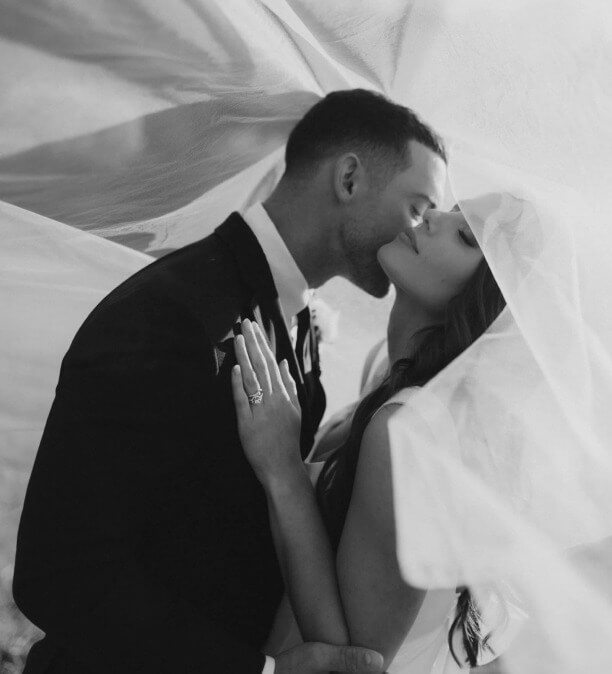 Сouple wearing a white gown and a black suit black and white photo